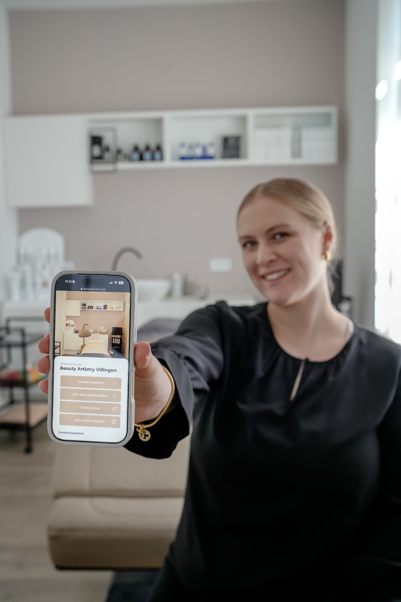 Jule Strelow zeigt die Online-Buchung von Beauty Artistry Villingen auf dem Smartphone